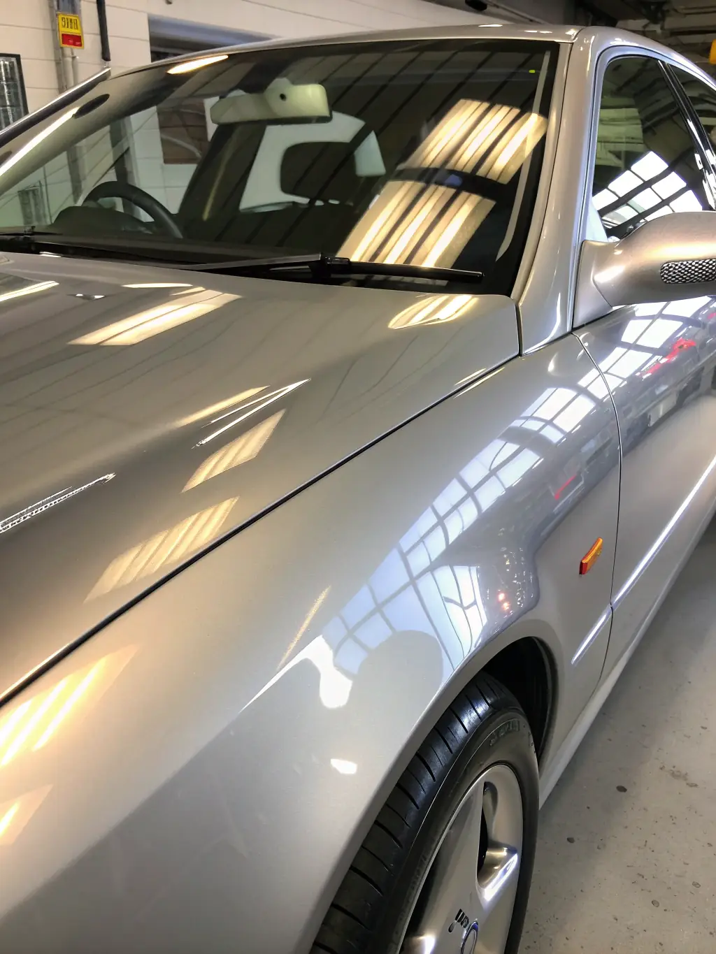 A before-and-after shot of a car's paint surface, demonstrating the transformative effects of paint correction on swirl marks and imperfections.